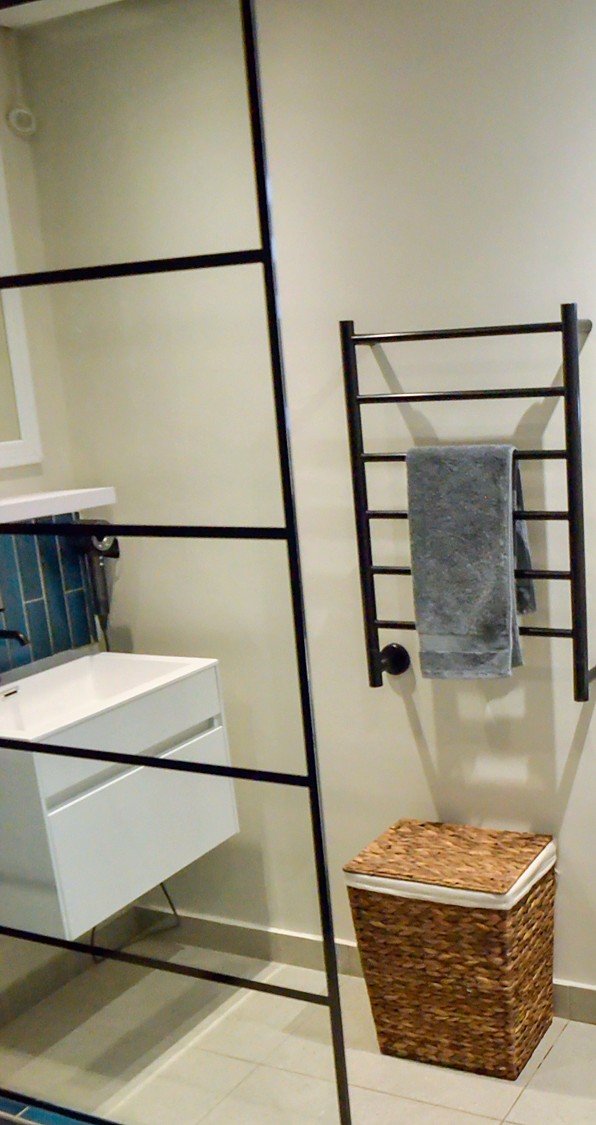 Bathroom with a walk-in shower, a basin and a heated towel rail