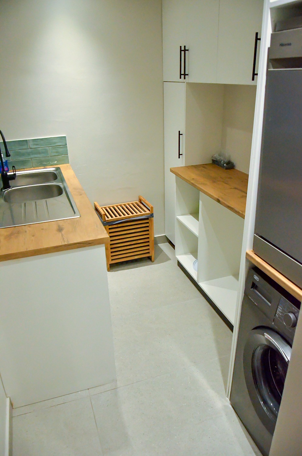 Scullery with a sink, a washing machine and storage