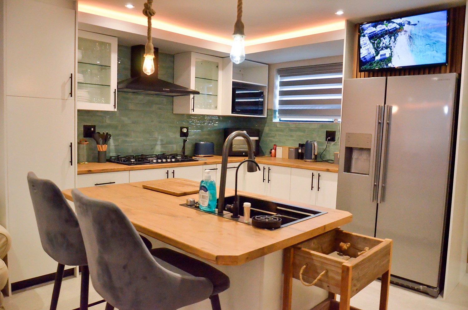 Kitchen island with bar stools and a fridge freezer