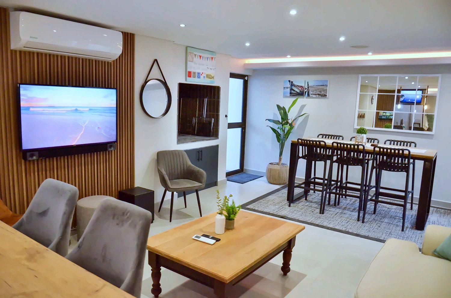 Memory Lane living area with a TV on a wooden slat wall and a high dining table