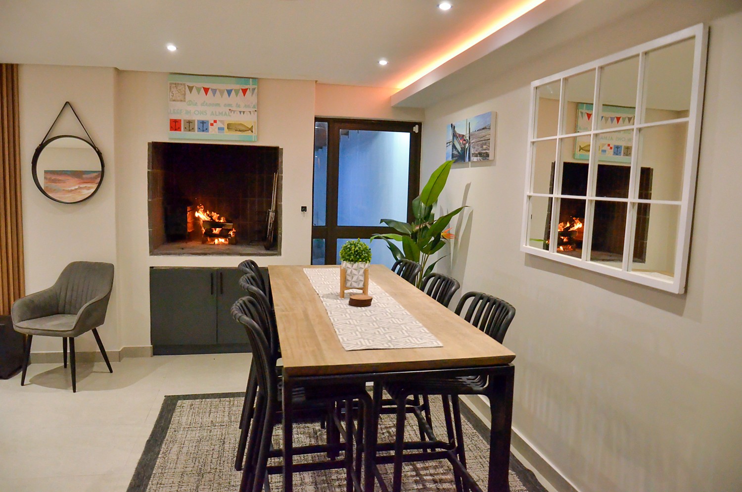 Dining area with a window-style mirror and the braai fire