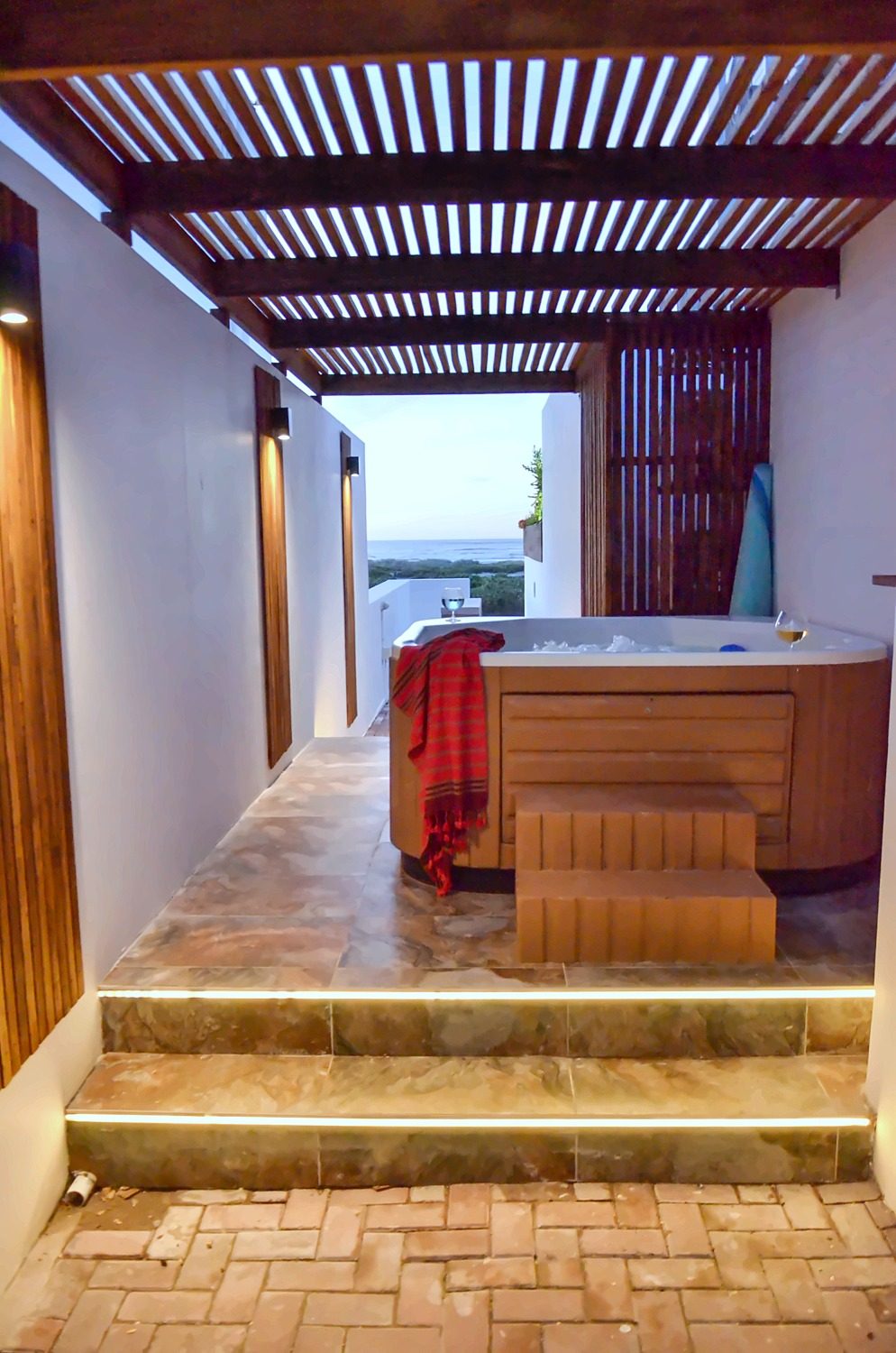 Lit steps leading under the pergola to the jacuzzi